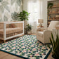 Modern nursery with a botanical wallpaper, crib, cozy armchair, and a colorful floral area rug.