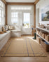 Popham Sand rug featuring a blue grid pattern in a bright, coastal-inspired entryway with bench seating and storage.