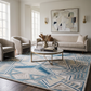 Galactic Celestial rug featuring a blue and cream geometric pattern in a modern, sunlit living room with neutral furniture.