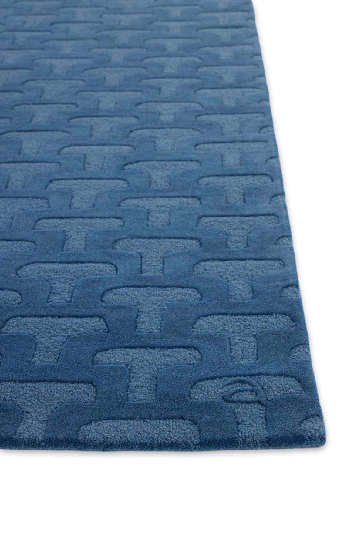 A detail corner of a deep blue textured, contemporary area rug called, Betty Blue by Angela Adams
