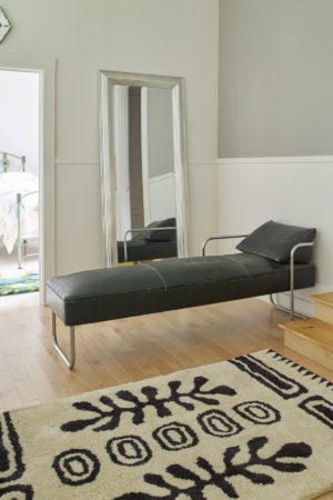 A lounge chair on a black and white, modern area rug called Drom Snow