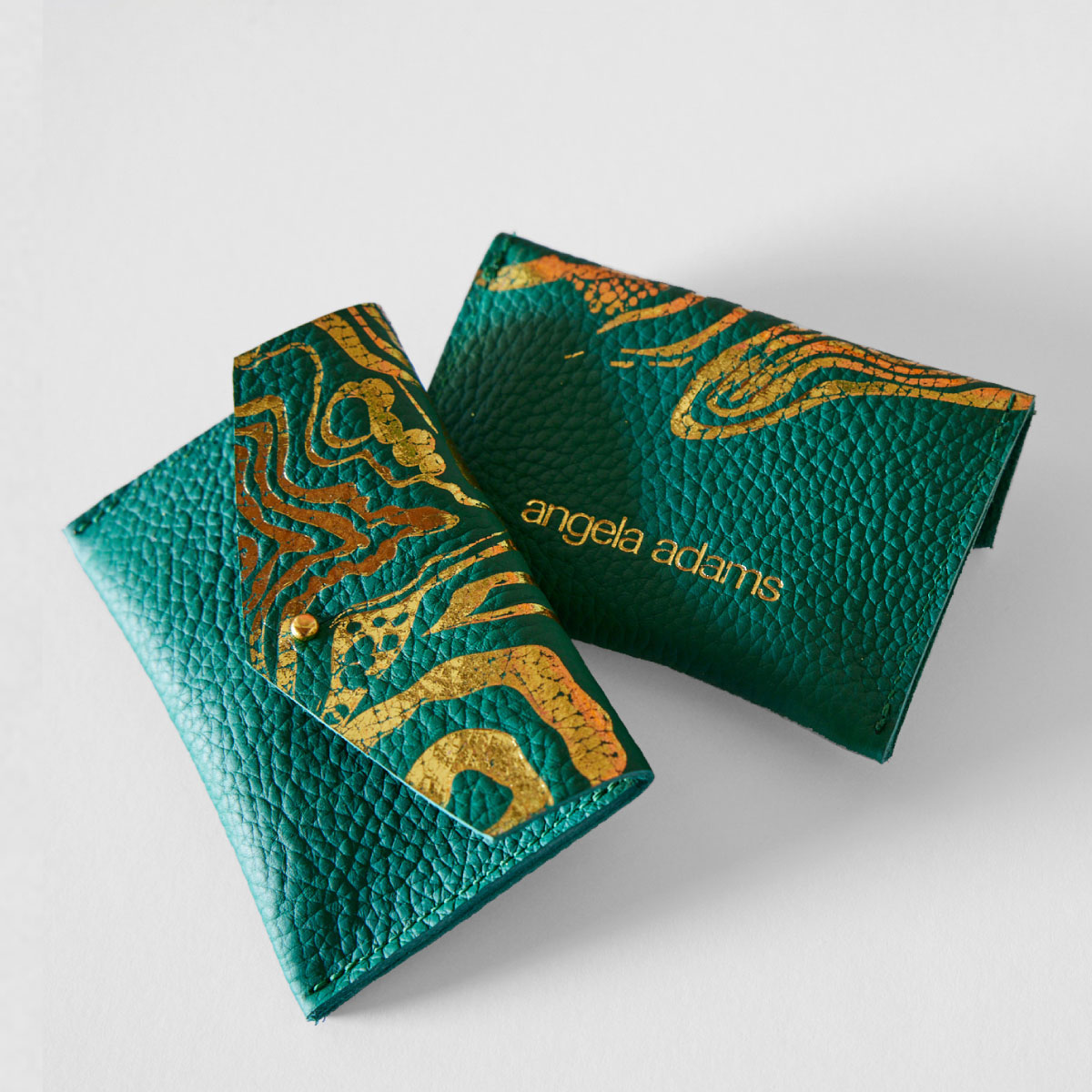 A textured green and gold, hand sewn, leather wallet called Nebula Grass by Angela Adams.