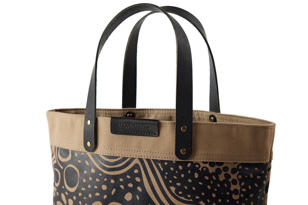 Label and detail of Brown and black tote by Angela Adams