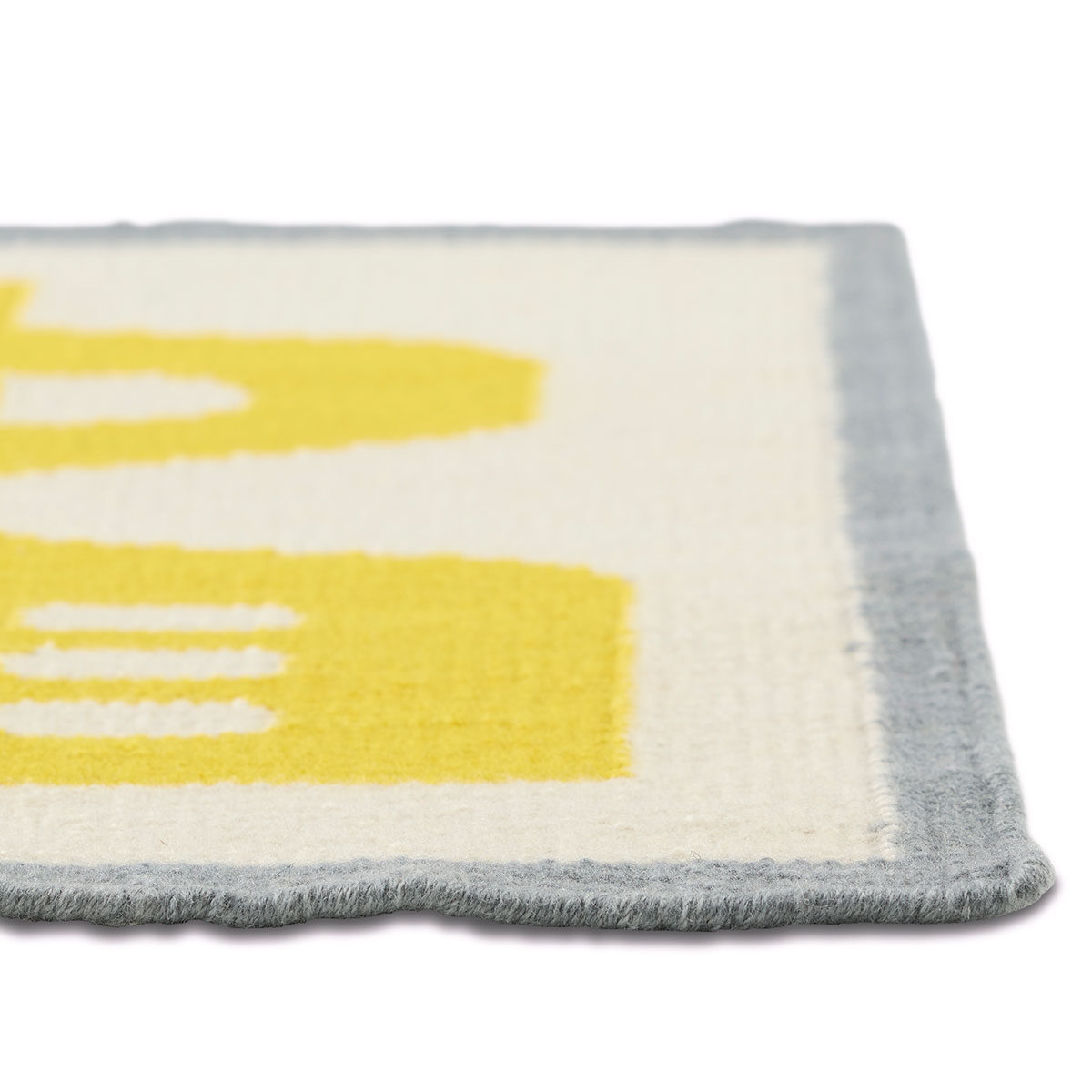 The corner of an abstract yellow and gray rug.