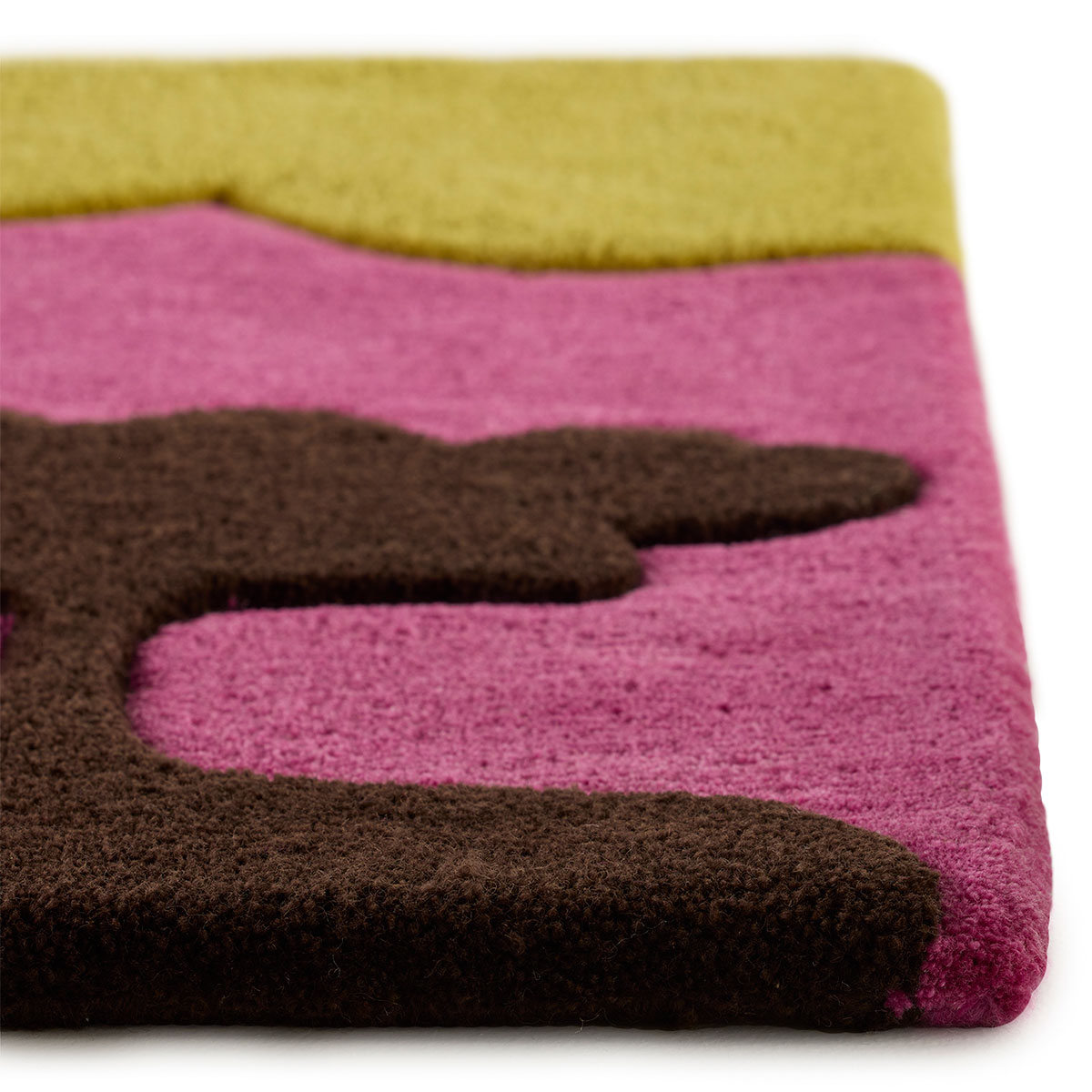 The corner detail of a pink and yellow rug with a scene of abstract trees on it called Island Family Sunset.
