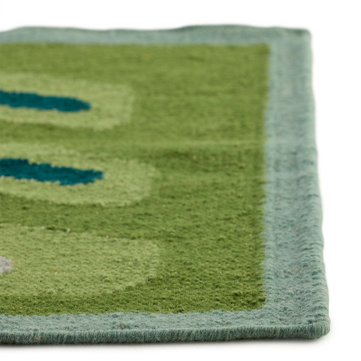 The corner detail of an abstract square small green rug named Pterapod Grass.