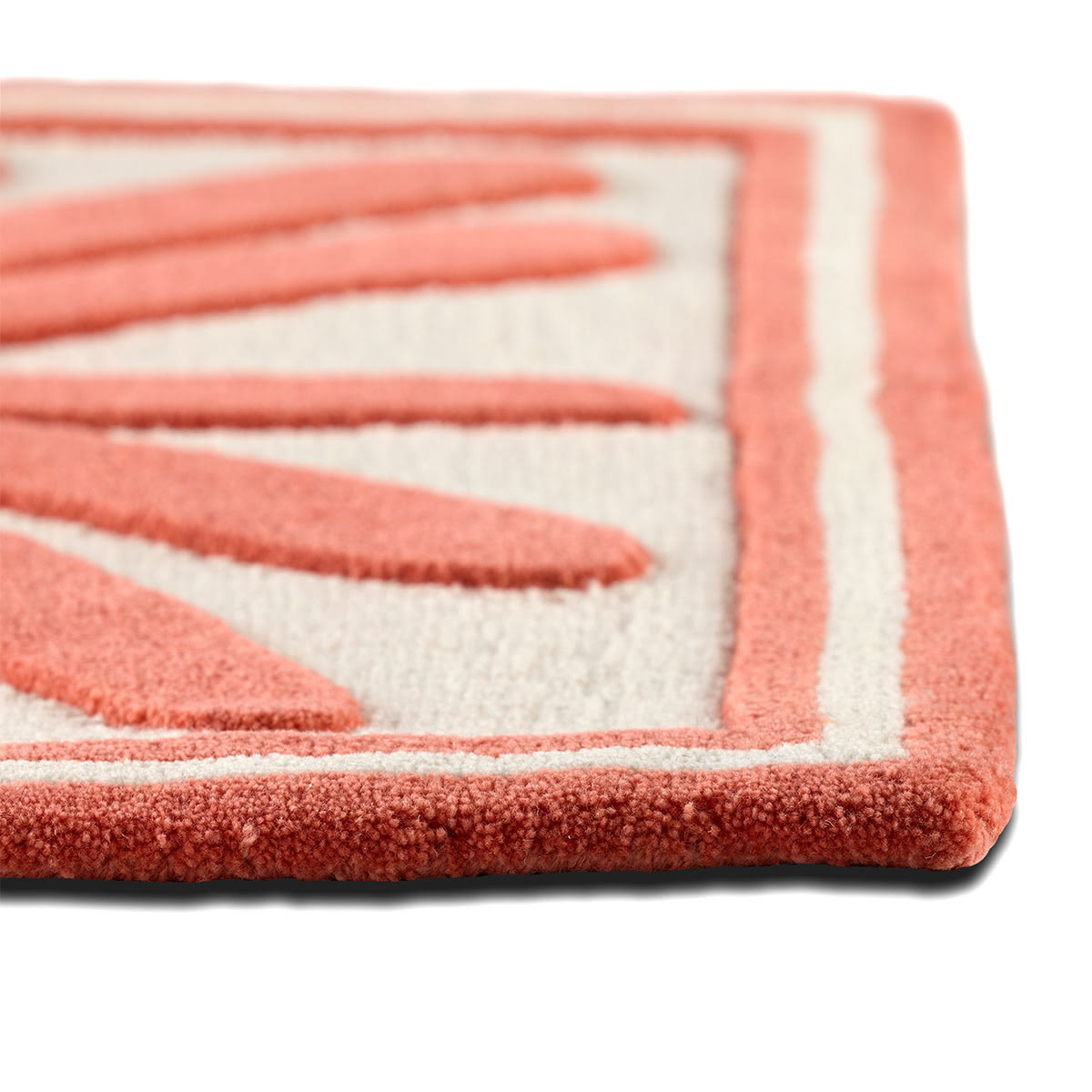 The corner of an abstract coral colored rug.