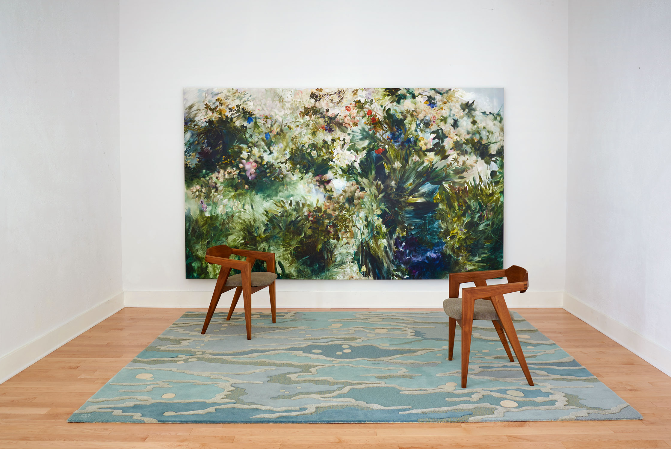 A modern area rug called Ocean Sea Glass sits below a large gallery painting.
