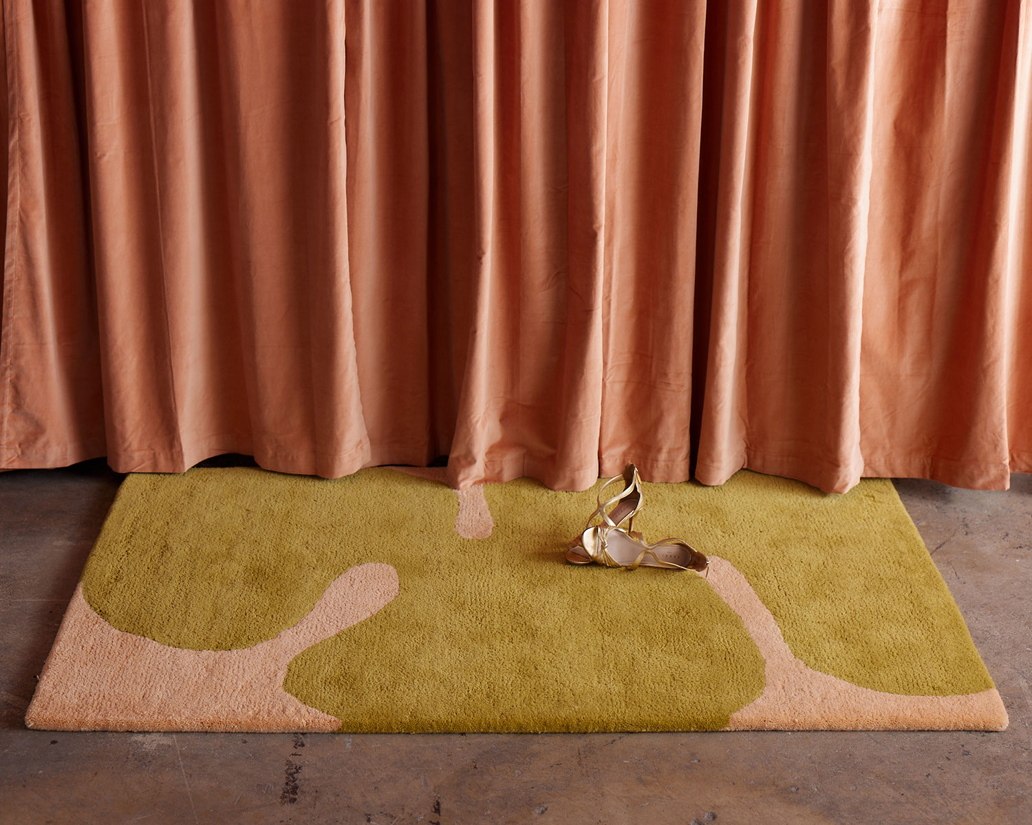 Astrud Melon area rug against a pearlescent curtain by Angela Adams