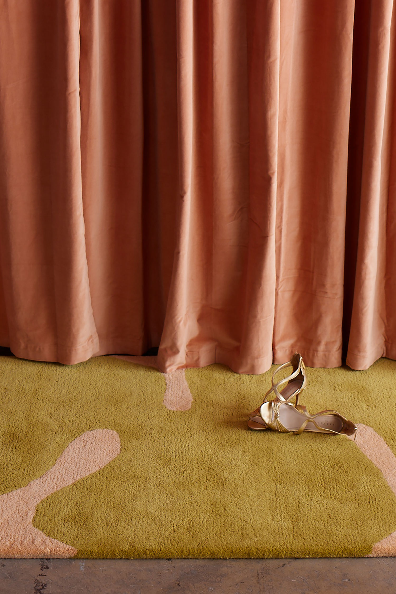 Astrud Melon area rug against a pearlescent curtain by Angela Adams