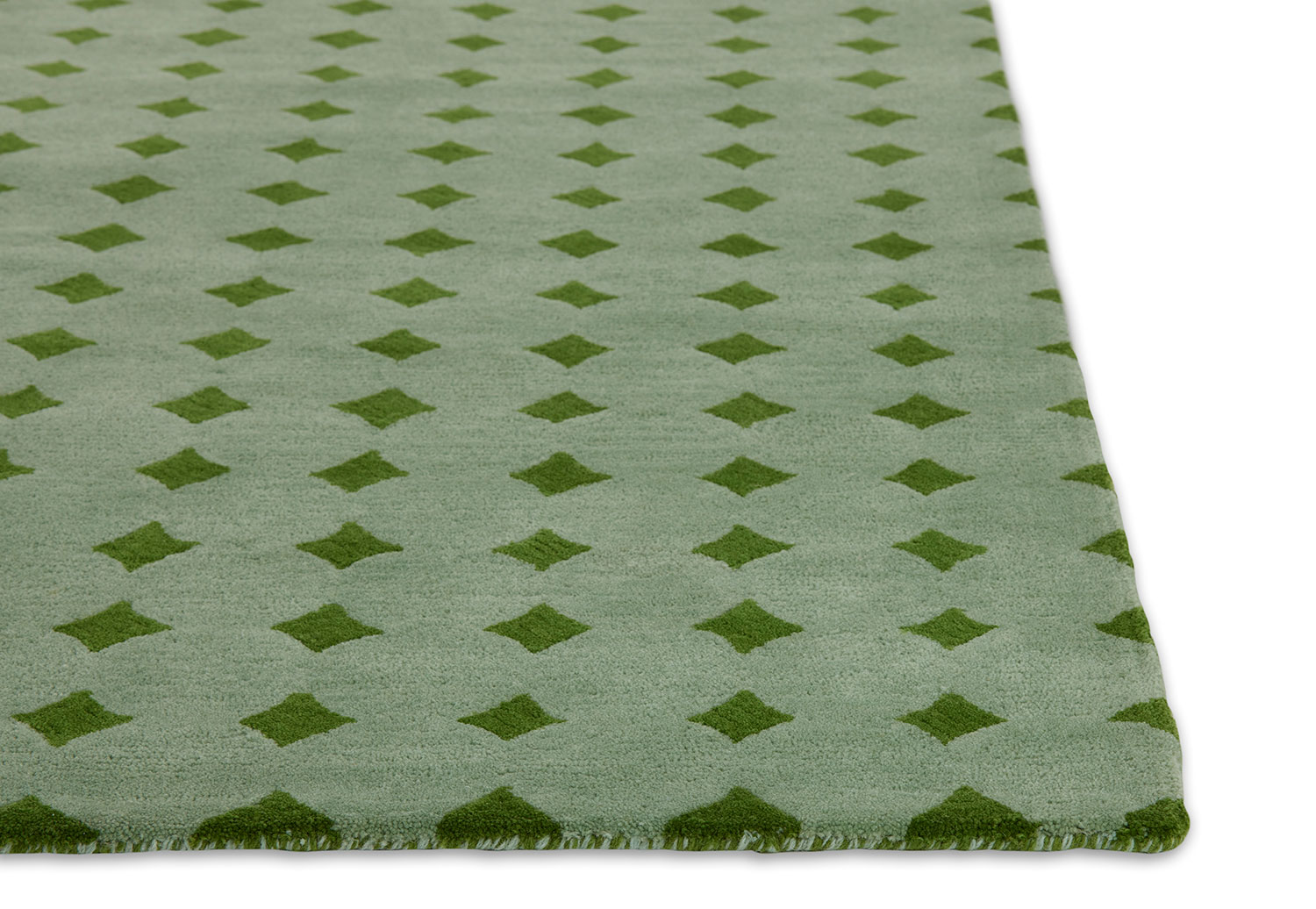 A close up corner of a green area rug called Bongo Fresca