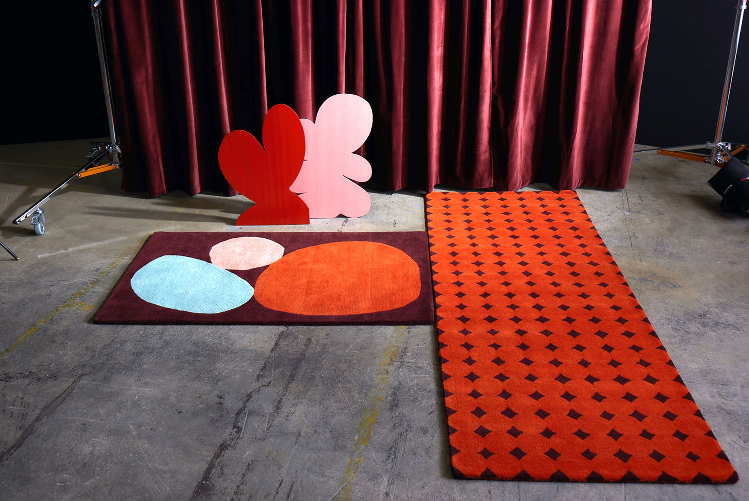A red rug called Bongo Passion on a gray cement floor