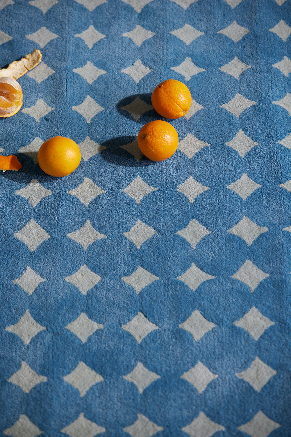 A blue area rug called Bongo Pool with oranges on it