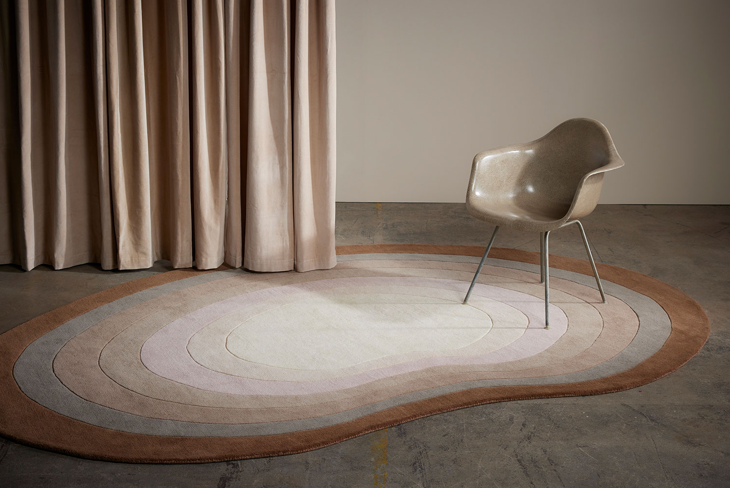 A modern chair sits on a neutral gradient area rug called Pool Heaven in the shape of a pool