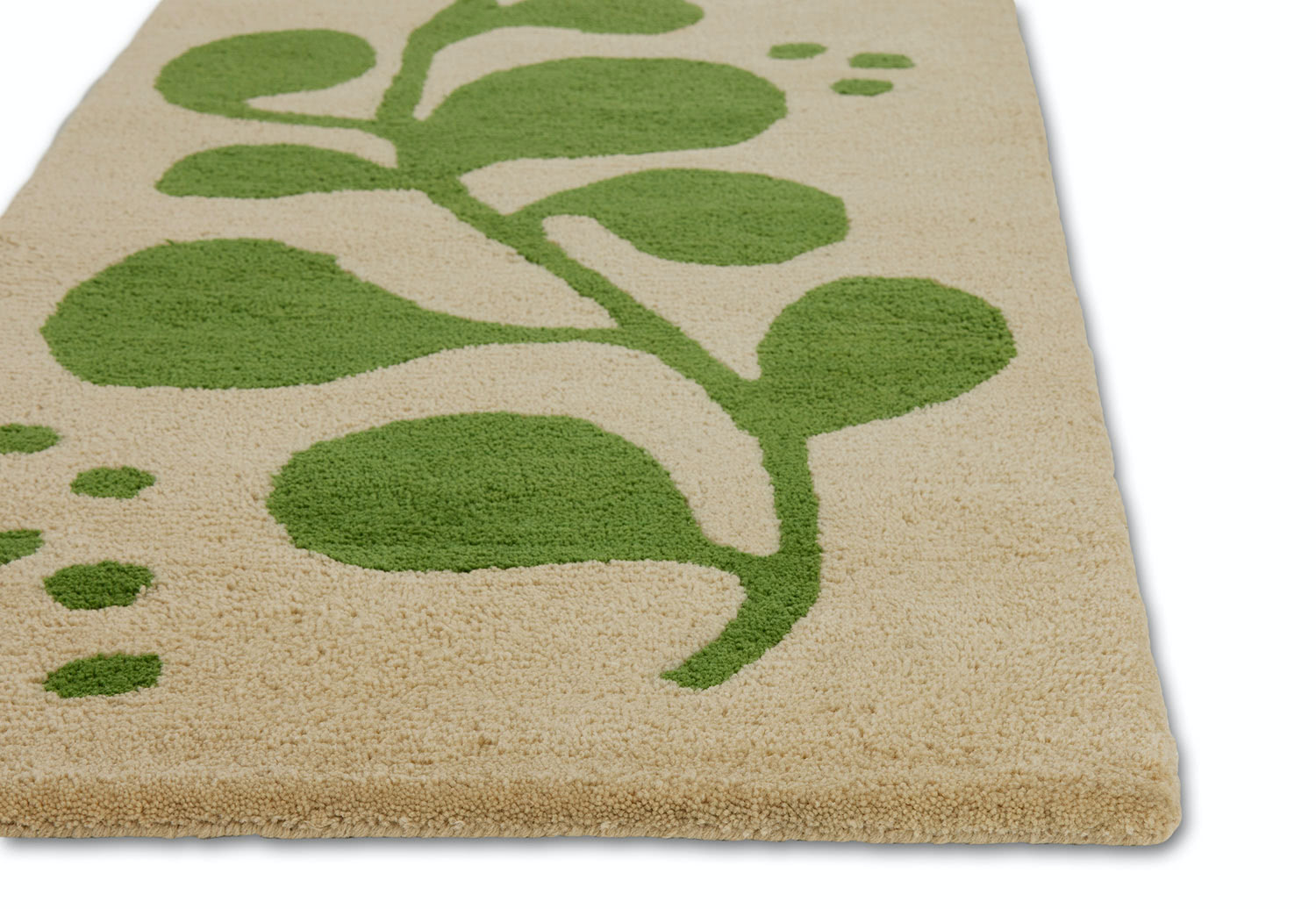 A corner detail of a neutral and green area rug with abstract designs on it called Vine Mambo