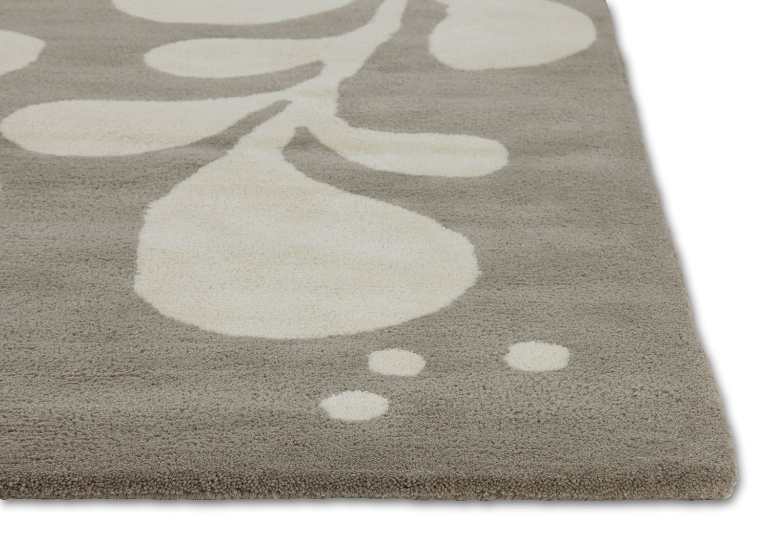 Corner detail of a neutral and gray area rug with abstract designs on it called Vine Swoosh