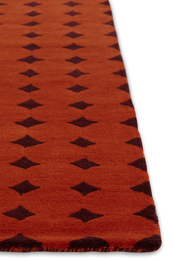 A close up corner of a red area rug called Bongo Passion