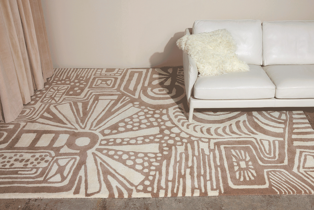 A beige and tan area rug called, Storybook is tickled with a shaggy pillow as it animates across the floor